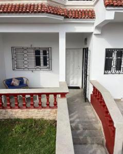 a white house with a red bench and a window at Maison front de mer in El Jadida
