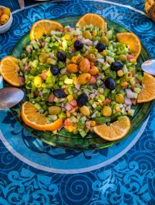 a plate of fruit and vegetables on a table at Sahara Peace in Mhamid +64 photos