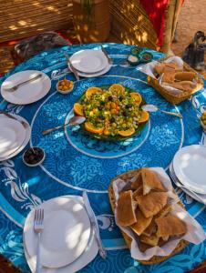 a blue table with a plate of food and bread at Sahara Peace in Mhamid