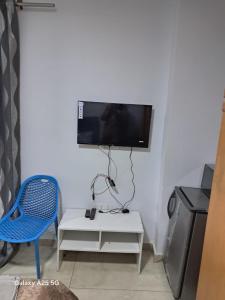 a living room with a white table and a tv on a wall at Cozy Private Studio DBL in ‘Ezbet `Abd el-Ḥamîd