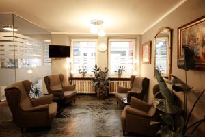 a waiting room with chairs and a mirror and windows at Hotel Paris in Düsseldorf