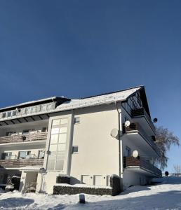 a white building with snow in front of it at Ferienwohnung Menges in Medebach