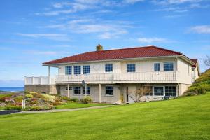 a white house with a red roof on a lawn at Apartment centrally located in Bud in Bud