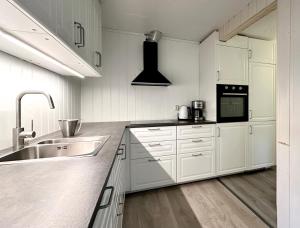 a white kitchen with white cabinets and a sink at Apartment centrally located in Bud in Bud