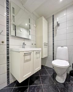 a white bathroom with a toilet and a sink at Apartment centrally located in Bud in Bud