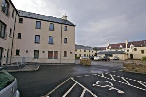 a parking lot in front of a large building at Ayre Hotel & Ayre Apartments in Kirkwall