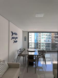 a living room with a table and chairs and a couch at Apartamento 1001 in Guarapari +11 photos