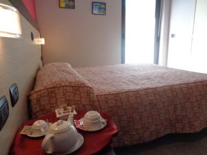 ein Hotelzimmer mit einem Bett und einem Tisch mit Teezubehör in der Unterkunft Hotel Airone in Trinitapoli