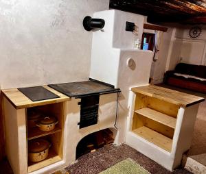 a small kitchen with a stove and a refrigerator at Chalúpka na kopčeku in Zuberec +4 photos
