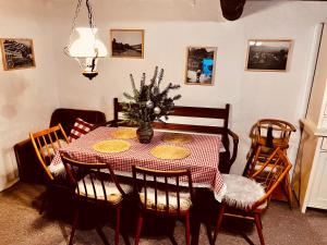 a dining room table with a red and white checkered table cloth at Chalúpka na kopčeku in Zuberec