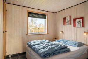 a bedroom with a bed with blue sheets and a window at SJ316-Hejls-Ronnebaervaenget-9 in Hejlsminde