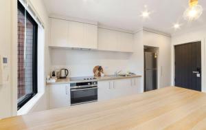 a kitchen with white cabinets and a large window at Relaxed Stay in Modern Comfort - By Superior Stays in Hamilton +5 photos