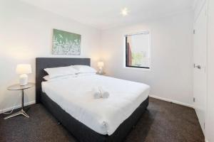 a bedroom with a large white bed with two white towels on it at Relaxed Stay in Modern Comfort - By Superior Stays in Hamilton