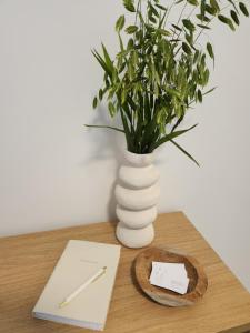 a wooden table with a vase with a plant in it at Verliefd in Brustem in Sint-Truiden