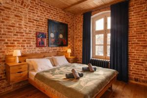 a bedroom with a bed and a brick wall at Apartamenty Dworzec Tleń in Tleń