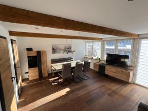a living room with a dining room table and chairs at Fichtelrooms in Fichtelberg