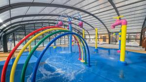 a water park with a bunch of colorful water slides at Séjour en Forêt 4 étoiles in Litteau