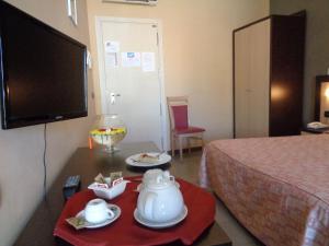 um quarto com uma cama e uma mesa com uma televisão em Hotel Airone em Trinitapoli