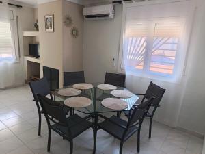a dining room with a glass table and chairs at Casa del Llimoner in L'Escala
