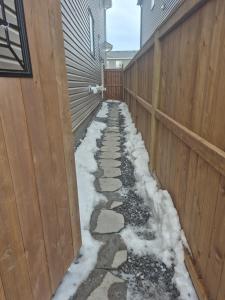 a sidewalk covered in snow next to a fence at Home away from Home in Calgary
