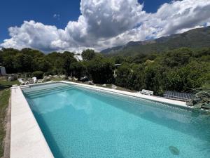 a large swimming pool with mountains in the background at Casita siempre verde in Los Hornillos
