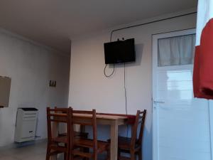 a room with a table and a television on a wall at Tafi Apart in Sarmiento