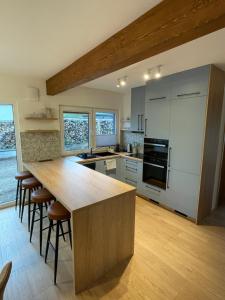 a kitchen with a large wooden island with bar stools at Chata-Elko Habovka in Habovka +25 photos