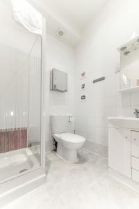 y baño blanco con aseo y ducha. en Imperial Court Studios, en Londres