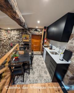 a kitchen and dining room with a table and a sink at Casinha das Mimosas in Sanfins do Douro