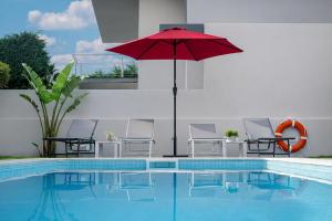 a red umbrella sitting next to a swimming pool at Sintra Dream Garden Villa near Cascais in Sintra