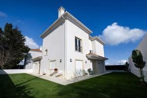 a large white house with a grass yard at Sintra Dream Garden Villa near Cascais in Sintra