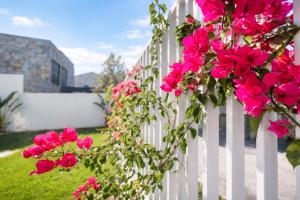 a white fence with pink flowers on it at Sintra Dream Garden Villa near Cascais in Sintra
