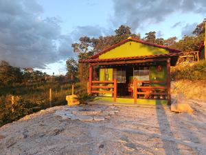 a small house with a yellow roof on a field at Chalé Corina in Pirenópolis