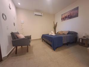 a bedroom with a bed and a chair at Recanto Tucuns-Guest House in Búzios