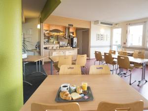 uma cafetaria com uma bandeja de comida numa mesa em B&B HOTEL Auxerre Monéteau em Monéteau