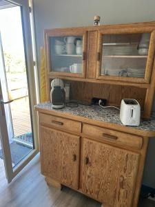 a kitchen with a wooden hutch with a coffee maker at Gîte de la Vigne in Ley +12 photos