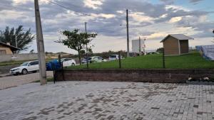 a street with cars parked on a grassy hill at APARTAMENTOS02 TERREO 01 quarto in Jaguaruna