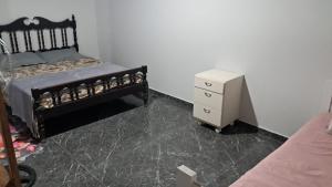 a bedroom with a bed and a small dresser at APARTAMENTOS02 TERREO 01 quarto in Jaguaruna