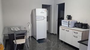 a kitchen with a refrigerator and a table and a table and a tableablish at APARTAMENTOS02 TERREO 01 quarto in Jaguaruna