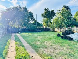 a yard with a fence and a grass field at Hei Stays Bachelor Apartment in Bronkhorstspruit