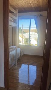 a bedroom with a bed and a large window at Tu Espacio en Rada in Rada Tilly