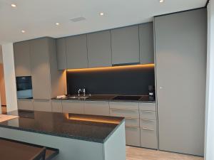 a kitchen with white cabinets and a black counter top at Sun Tower in Zurich +22 photos