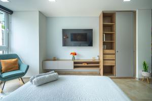 a bedroom with a bed and a tv and a chair at Loft 202 North Cali - Montsari in Cali