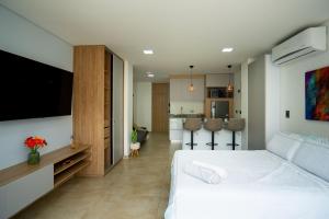 a bedroom with a large white bed and a kitchen at Loft 202 North Cali - Montsari in Cali