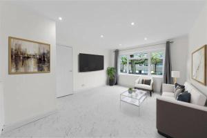 a white living room with a couch and a tv at THAMES LODGE SPACIOUS 4 BEDROOM HOUSE WITH GARDEN FREE PARKING WIFi SLEEPS 8 ENTIRE HOME in Kent