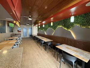 ein Restaurant mit Holztischen und Pflanzen an der Wand in der Unterkunft Hotel Montecarlo in Riobamba