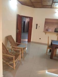 ein Zimmer mit zwei Stühlen und einem Tisch und eine Küche in der Unterkunft Godfils in Abomey-Calavi + 35 Fotos