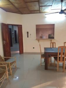 eine Küche und ein Esszimmer mit Tisch und Stühlen in der Unterkunft Godfils in Abomey-Calavi