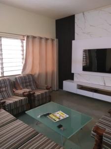 ein Wohnzimmer mit zwei Stühlen und einem Glastisch in der Unterkunft Godfils in Abomey-Calavi