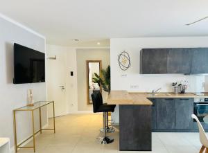 a kitchen with blue cabinets and a black chair at YAYstay - comfy Lofts in Rosenheim in Rosenheim